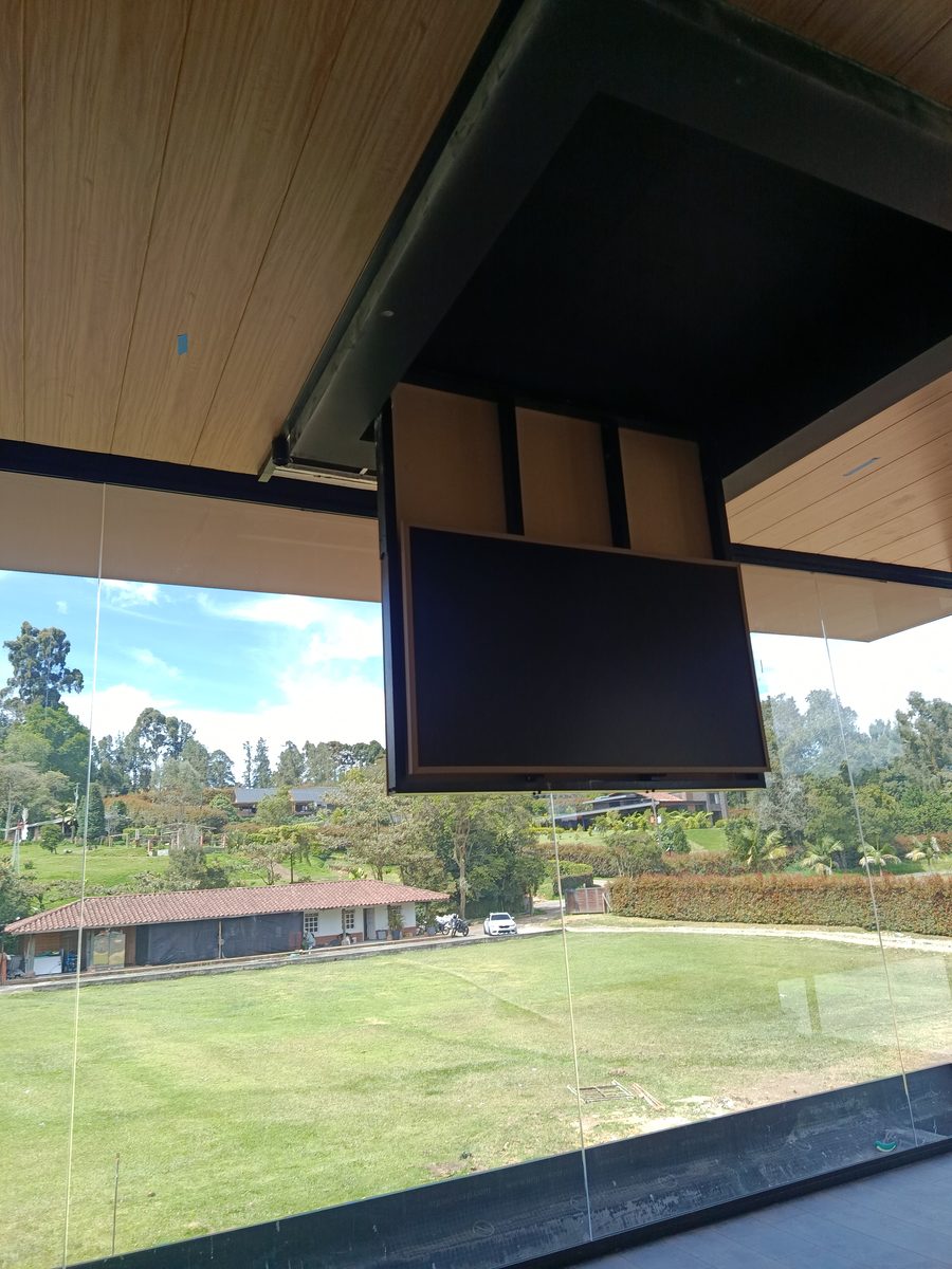 Ascensor TV en terraza exterior con techo de madera